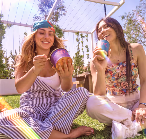 Two friends enjoying Rawberry cups outdoors in the sun